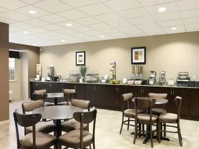 a waiting room with tables and chairs and a counter at Microtel Inn & Suites Mansfield PA in Mansfield