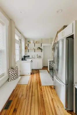 a kitchen with a refrigerator and wooden floors at Quaint Boho Home in Lancaster City in Lancaster