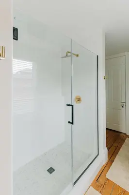a shower with a glass door in a bathroom at Quaint Boho Home in Lancaster City in Lancaster