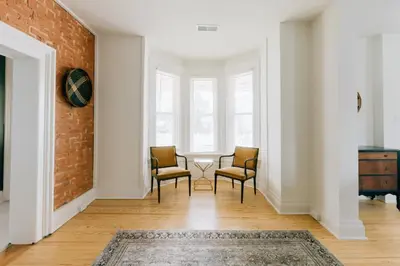 a living room with two chairs and a brick wall at Newly Renovated Vintage Inspired Large 4 BR Home in Mount Joy
