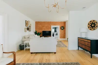 a living room with a white couch and a brick wall at Newly Renovated Vintage Inspired Large 4 BR Home in Mount Joy