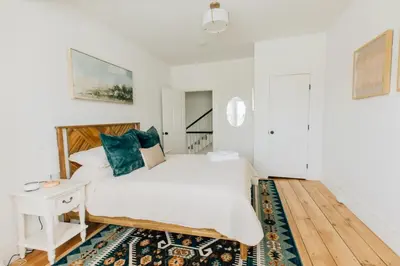 a white bedroom with a bed and a night stand and a table at Newly Renovated Vintage Inspired Large 4 BR Home in Mount Joy