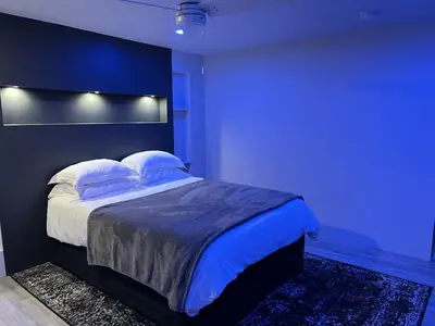 a blue bedroom with a large bed with pillows at Silva Domus in West Orange