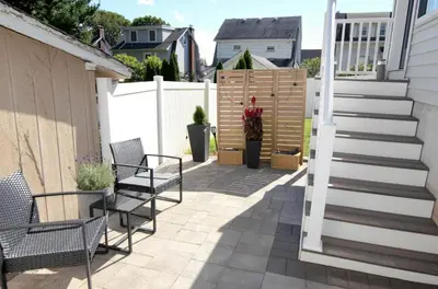 a patio with chairs and stairs next to a fence at Silva Domus in West Orange