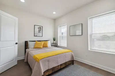 a bedroom with a bed and two windows at Modern City living in Philadelphia