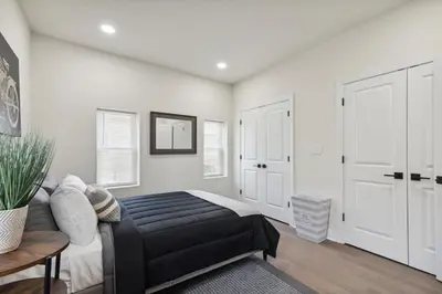 a bedroom with a black bed and white walls at Modern City living in Philadelphia