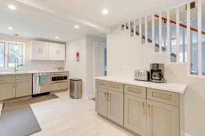 a kitchen with white cabinets and a staircase at Pennington Home with Deck about 9 Mi to Princeton! in Pennington