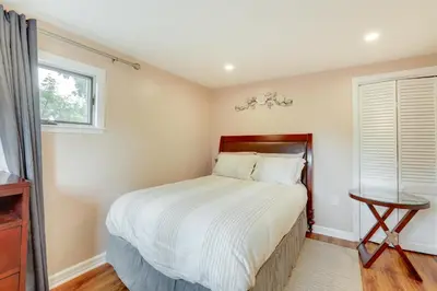 a bedroom with a large bed and a window at Pennington Home with Deck about 9 Mi to Princeton! in Pennington