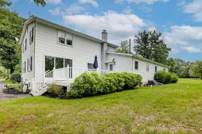 a white house with a large yard at Pennington Home with Deck about 9 Mi to Princeton! in Pennington