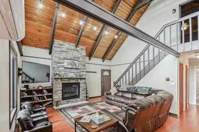 a living room with a couch and a fireplace at Poconos Chalet newly renovated, great location home in Tobyhanna