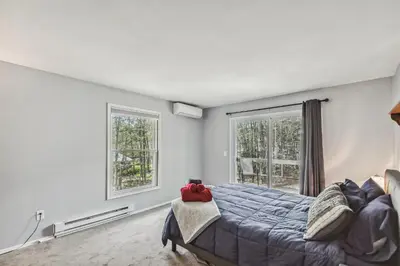 a bedroom with a bed and two windows at Poconos Chalet newly renovated, great location home in Tobyhanna