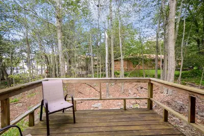 a wooden deck with a chair sitting on it at Poconos Chalet newly renovated, great location home in Tobyhanna