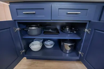 a blue cabinet with pots and pans in it at Beach house - 3BR Beach Gem - 30ft to Sand & Walk to Amusement Park in Keansburg