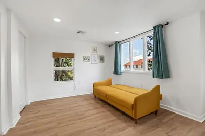 a living room with a yellow couch and a window at Beach house - 3BR Beach Gem - 30ft to Sand & Walk to Amusement Park in Keansburg