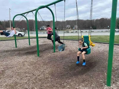 a group of children sitting on swings at a playground at Tranquil Getaway in the Pocono Mountains in Thornhurst