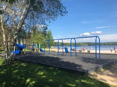 a playground in a park next to a beach at Tranquil Getaway in the Pocono Mountains in Thornhurst