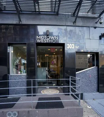 a storefront of a store with a sign on it at Midtown West Hotel in New York