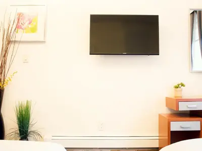 a living room with a flat screen tv on the wall at Midtown West Hotel in New York