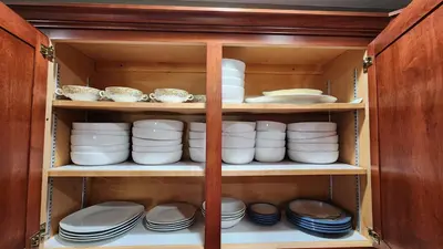 a cabinet filled with plates and bowls and dishes at Entire townhouse close to Hershey Park in Enola