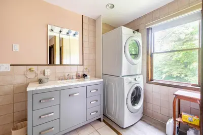 a bathroom with a washing machine and a sink at Bethel Woods Retreat - wPool, Hot Tub & Arcade! in Mongaup Valley