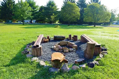 a garden with logs and benches in the grass at Farm Country House with Pool and Huge Property in Blakeslee