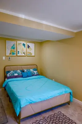 a bedroom with a bed with a blue comforter at Farm Country House with Pool and Huge Property in Blakeslee