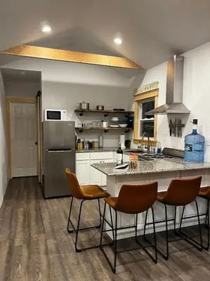 a kitchen with a counter with chairs and a refrigerator at Bethel Woods Cabin in Mongaup Valley