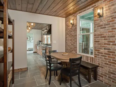 a dining room with a brick wall and a table and chairs at Luxuriously Restored Farm Cabin in Mountainhome
