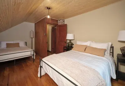 a bedroom with a bed and a bench in it at Luxuriously Restored Farm Cabin in Mountainhome