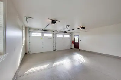 an empty garage with white walls and white garage doors at Patio and Yard Newly Built Retreat in Ronks! in Ronks