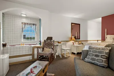 a bedroom with a bed and a bathroom with a tub at Country Living Inn in Lancaster