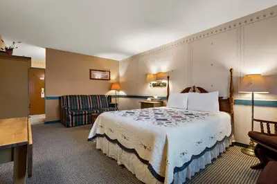 a hotel room with a bed and a chair at Country Living Inn in Lancaster
