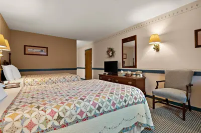 a hotel room with a bed and a chair at Country Living Inn in Lancaster