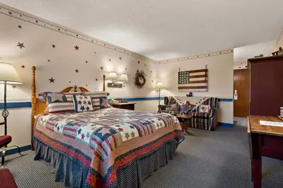 a bedroom with a bed and a desk and a chair at Country Living Inn in Lancaster