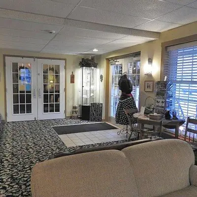 a woman sitting at a table in a living room at Country Living Inn in Lancaster