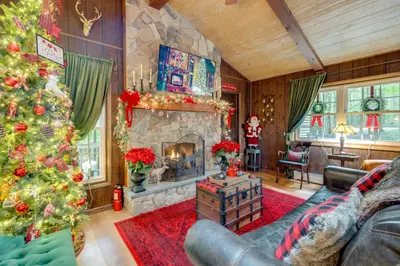 a living room with a christmas tree and a fireplace at 1 Mi to Gouldsboro State Park Cabin with Deck! in Gouldsboro