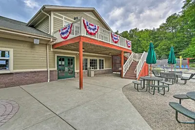 a playground with tables and umbrellas in front of a building at 1 Mi to Gouldsboro State Park Cabin with Deck! in Gouldsboro