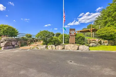 a sign with an american flag in a parking lot at 1 Mi to Gouldsboro State Park Cabin with Deck! in Gouldsboro