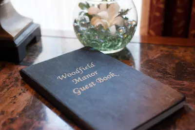 a book sitting on top of a table with a vase at Woodfield Manor - A Sundance Vacations Property in Cresco
