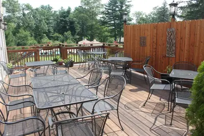 a bunch of tables and chairs on a deck at Woodfield Manor - A Sundance Vacations Property in Cresco