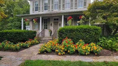 a house with a bunch of flowers in front of it at Pinetown Bridge Bnb LLC in Leola