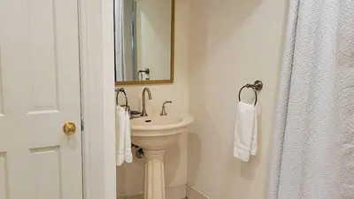 a white bathroom with a sink and a mirror at Pinetown Bridge Bnb LLC in Leola