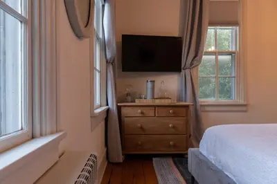 a bedroom with a bed and a dresser with a television at Pinetown Bridge Bnb LLC in Leola
