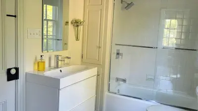 a white bathroom with a sink and a shower at Pinetown Bridge Bnb LLC in Leola