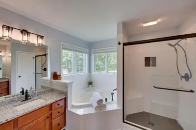 a bathroom with a tub and a shower with a glass door at Game Room and Covered Patio Hummelstown Hideaway in Hummelstown