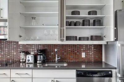 a kitchen with white cabinets and a black counter top at Gorgeous Midtown W 1BR w Gym nr Times Sq NYC-651 in New York