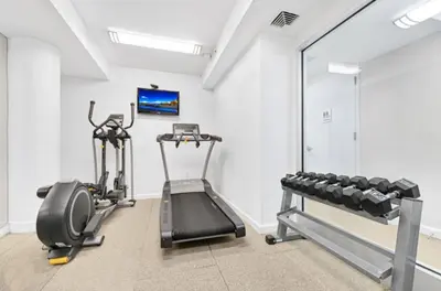 a gym with two tread machines and a mirror at Gorgeous Midtown W 1BR w Gym nr Times Sq NYC-651 in New York