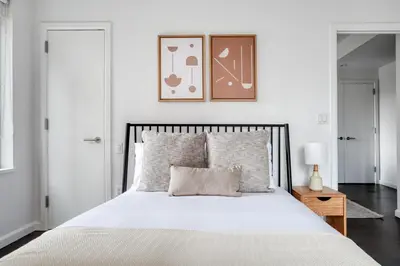 a bedroom with a large white bed with a picture on the wall at Gorgeous Midtown W 1BR w Gym nr Times Sq NYC-651 in New York