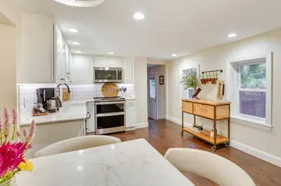 a kitchen with white cabinets and a table and chairs at Upper Black Eddy Home with Delaware River Access! in Upper Black Eddy