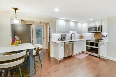 a kitchen with white cabinets and a table and chairs at Upper Black Eddy Home with Delaware River Access! in Upper Black Eddy